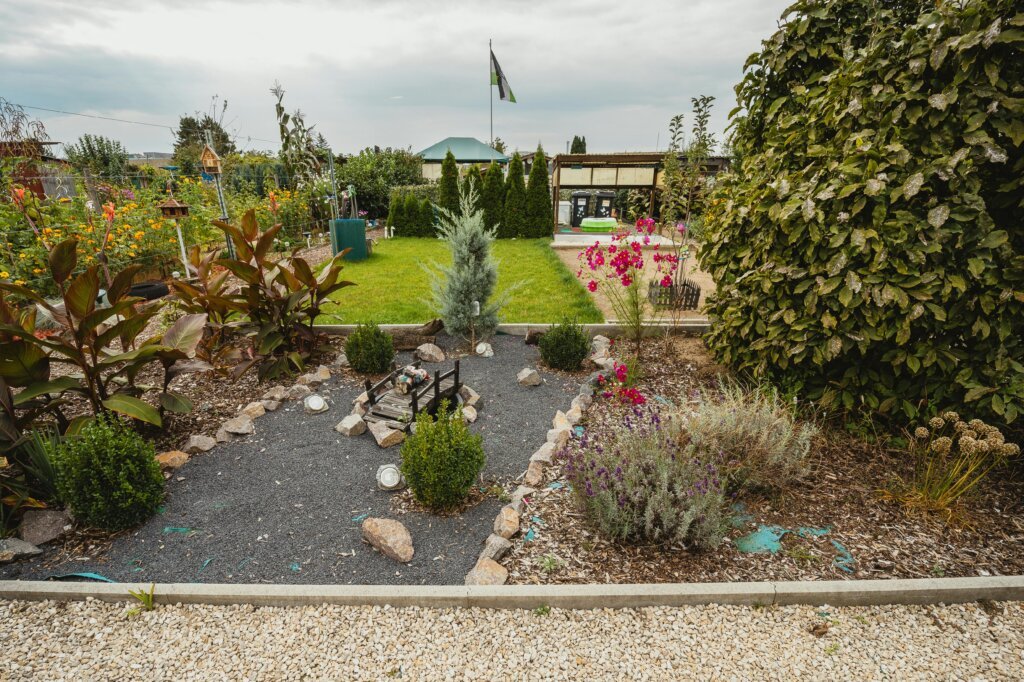 Explore a vibrant community garden featuring lush greenery, colorful flowers, and a quaint stone pathway.